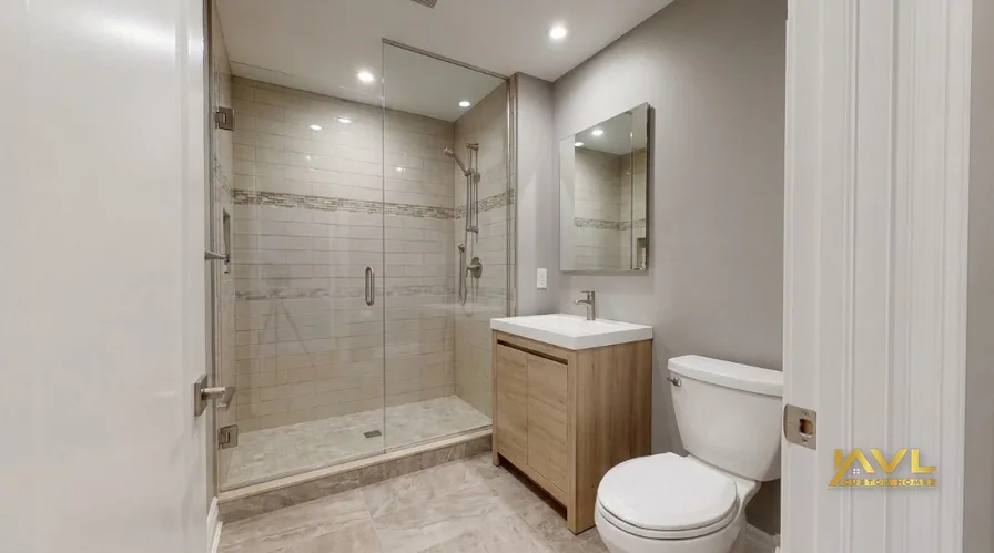 Finished moisture-resistant basement bathroom with tile and glass shower in a Toronto detached home